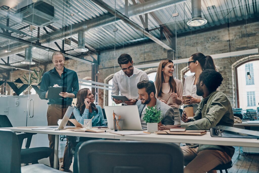 Group of young people communicating and using computer while working in the office