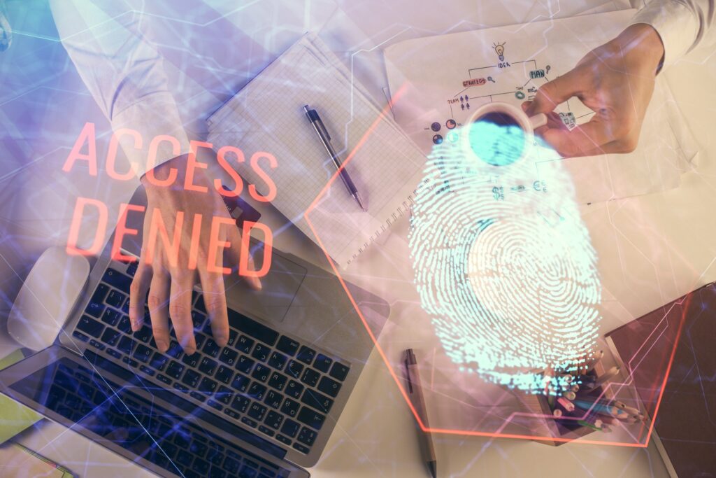 Man's hands typing over computer keyboard and finger print hologram.